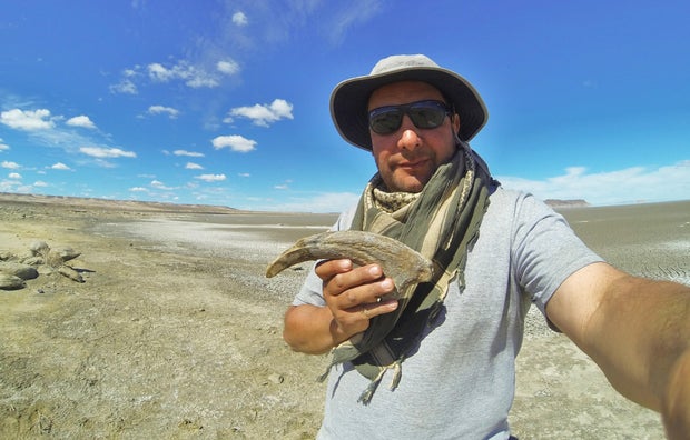 Researcher Marcelo Luna holds the claw of a close relative of the Cretaceous meat-eating dinosaur Joaquinraptor 