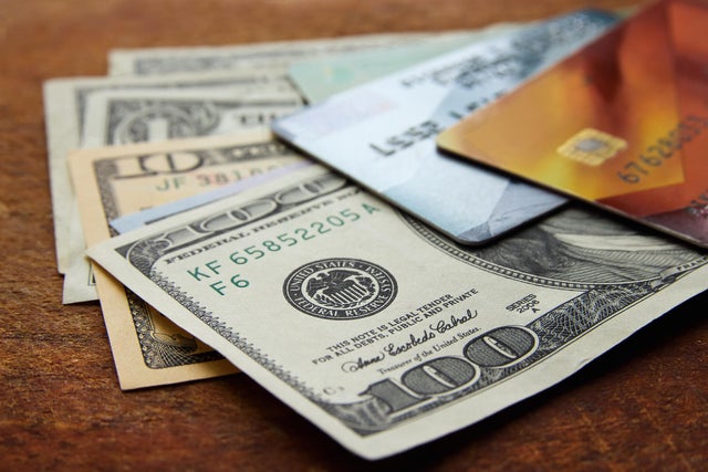 american dollar bills and plastic credit cards on wooden background 