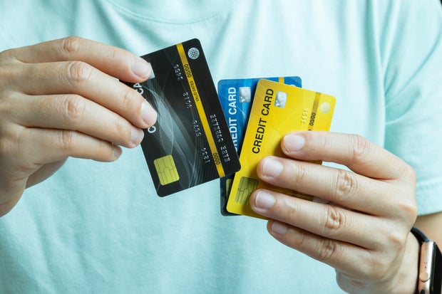 Man holding several credit cards and he is choosing a credit card to pay and spend Payment for goods via credit card. Finance and banking concept