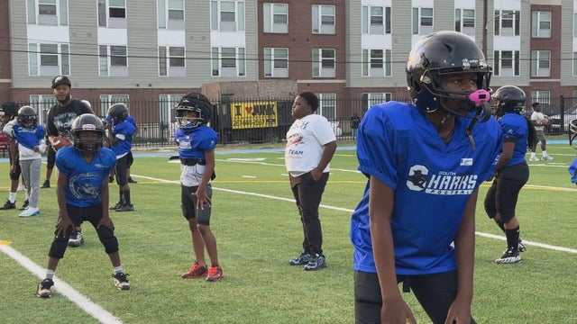 Youth football players prepare for a drill on the field at Vare Recreation Center 