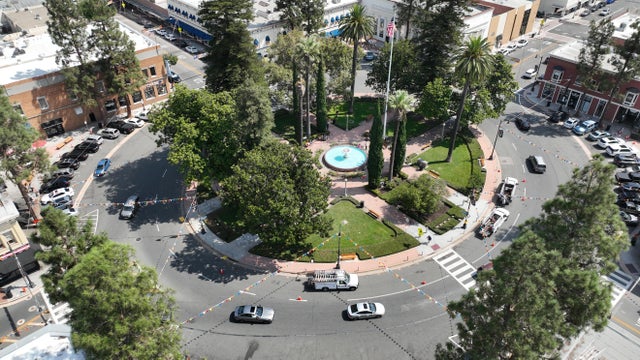 An aerial view of workers and people walking through Old Towne Orange Plaza Park near the historic fountain at the center of the circle in Old Towne Orange that was damaged again when a suspected DUI driver plowed into the plaza. 