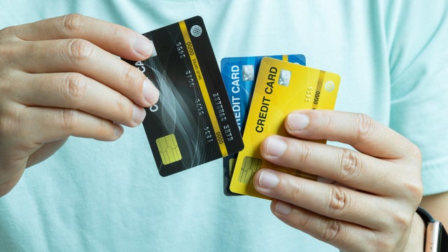 Man holding several credit cards and he is choosing a credit card to pay and spend Payment for goods via credit card. Finance and banking concept 