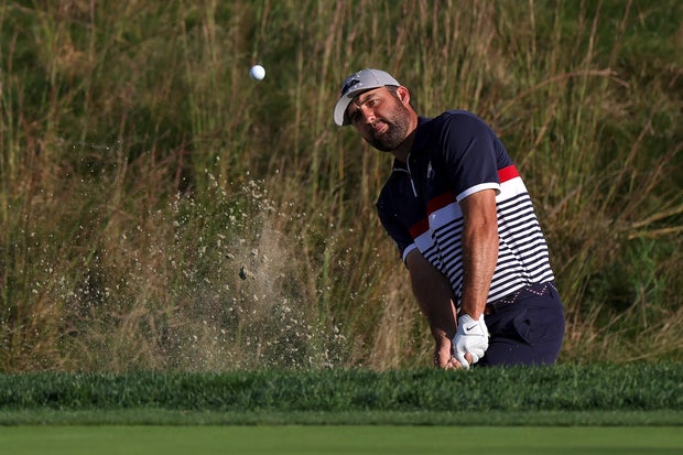 Scottie Scheffler of Team United States hits out of a greenside bunker on the 14th hole during the Friday afternoon four-ball matches of the 2025 Ryder Cup at Black Course at Bethpage State Park Golf Course on September 26, 2025 in Farmingdale, New York.