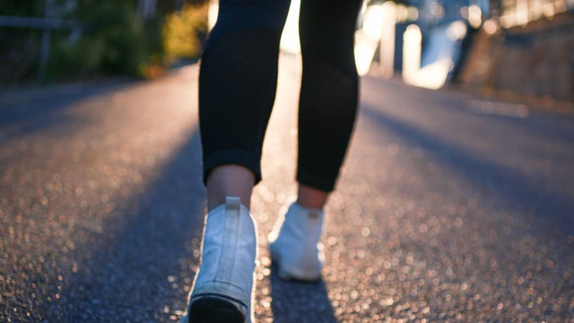 Feet walking in white sneakers 