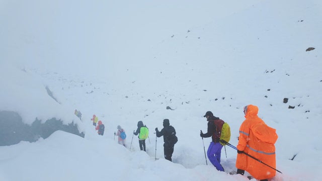 A screen capture from video shows trekkers leaving their campsite, as unusually heavy snow and rainfall pummeled the Himalayas, in the Tibet Region 