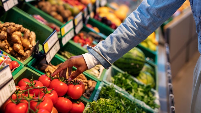 Woman buying fresh vegetables at supermarket 