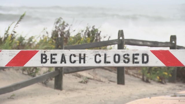 A Beach Closed sign near the beach at the Jersey Shore during a nor'easter 