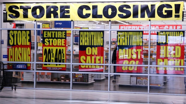 Store closing signs in retail store window 