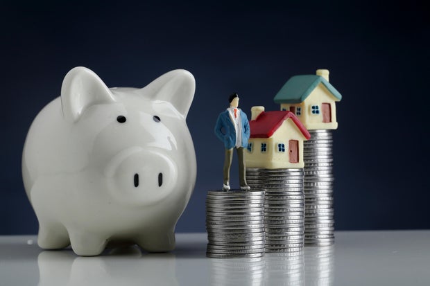 Piggy bank,model house and stack of coins-Concept of money saving 