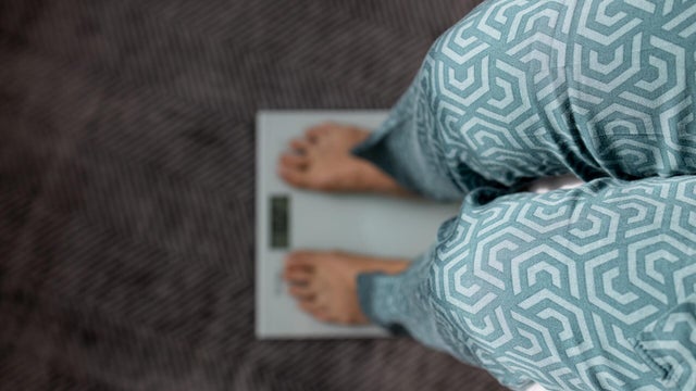 Close-up of unrecognizable woman standing on weight scales. High angel view 