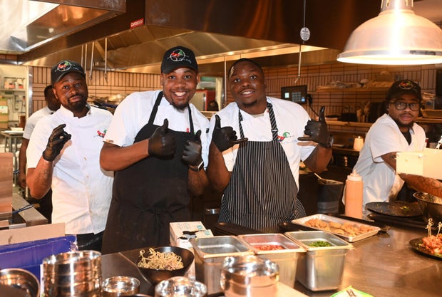 People post for a photo at the opening of Kitchen + Kocktails, a restaurant in Philadelphia
