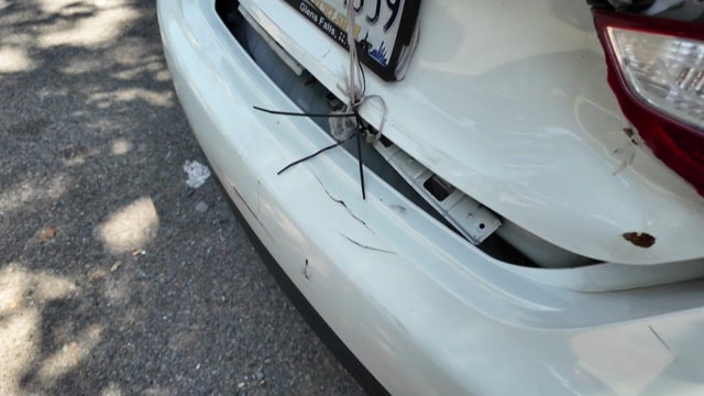 String holds a vehicle's trunk mostly closed 