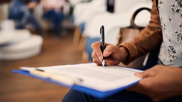 woman filling out medical documents in waiting room