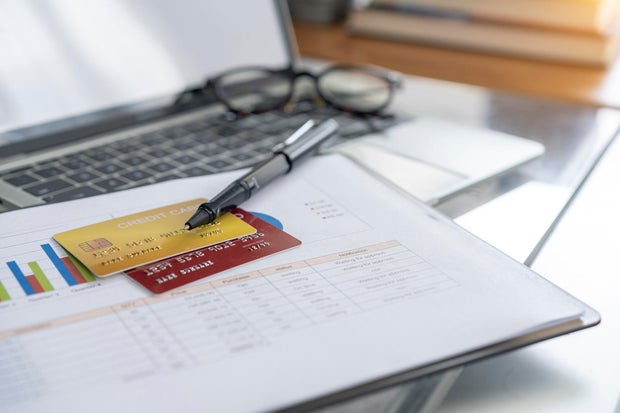 View of desk with credit card in the wallet on computer laptop. 