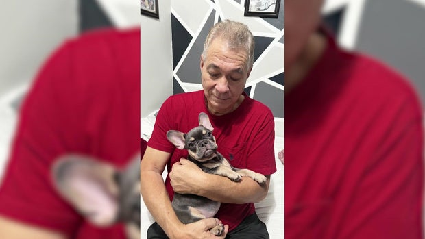 John Ospina holding Frenchie dog 