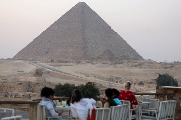 Tourists sit at a restaurant next to the Great Pyramid of Khufu, ahead of the Grand Egyptian Museum's opening, in Giza