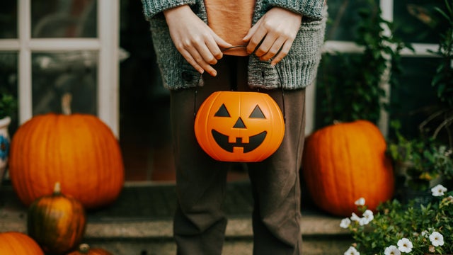 boy holding a halloween cup full of candies