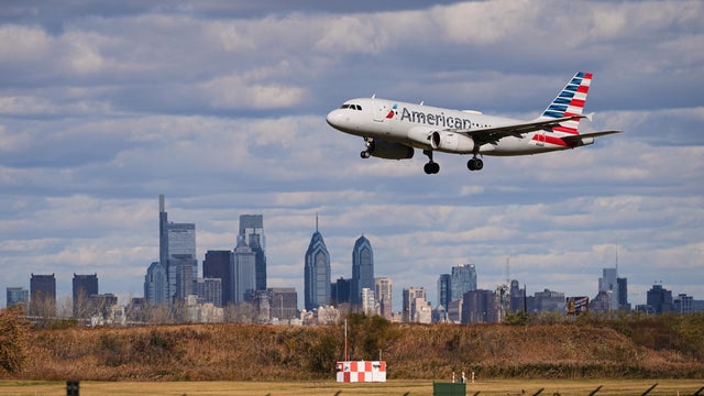 American airlines plane comes in to land at Philadelphia International Airport, skyline in the background 