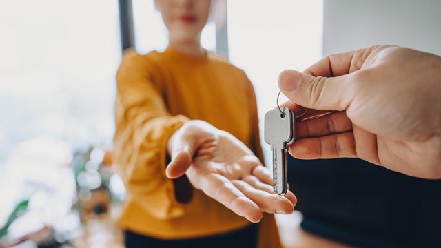 Close-up shot of a real estate agent giving a young Asian woman the keys to her new home. Home ownerships concepts 