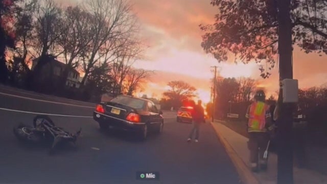Police body cam video shows the bike on the road behind the car, the sunset is bright 