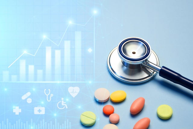 Healthcare business graph and data of medical business growth and a stethoscope with multi colored pills 