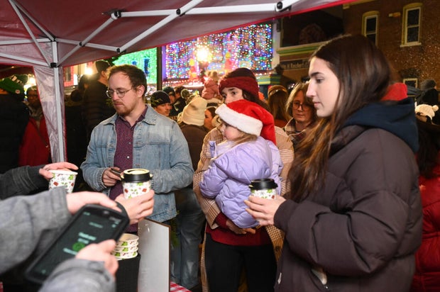 People pose for photos during a holiday event in Manayunk 