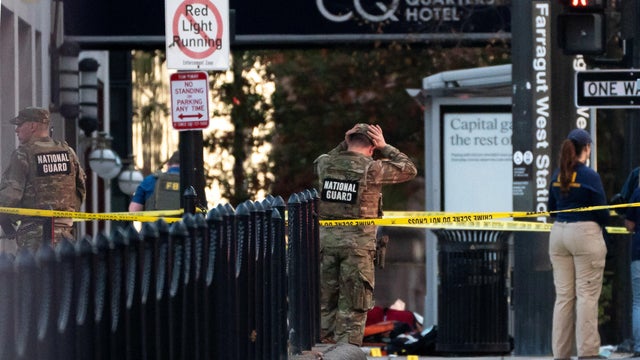 National Guard members stand together behind yellow tape after two guard members were shot near the White House in Washington, D.C., Nov. 26, 2025. 