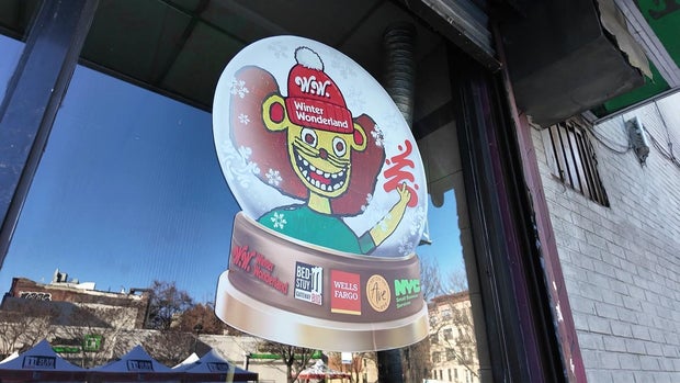 Cartoon of a lion in a snow globe in a storefront window