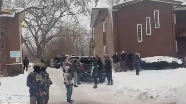 a close-up view of a police vehicle with blue lights patrolling near a public park with the windows and doors closed 