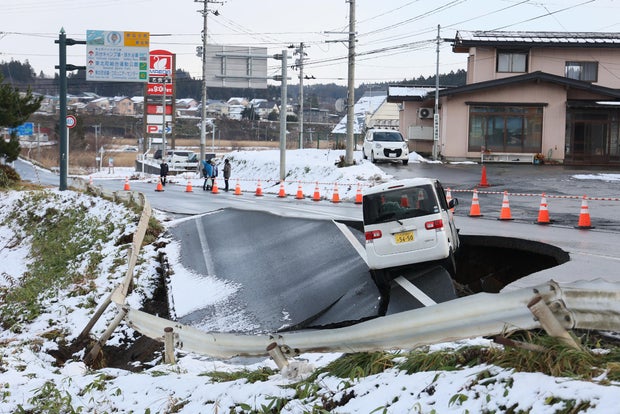 A vehicle rests on the edge of a collapsed road in Tohoku town in Aomori Prefecture on Dec. 9, 2025, following a 7.5 magnitude earthquake off northern Japan. 