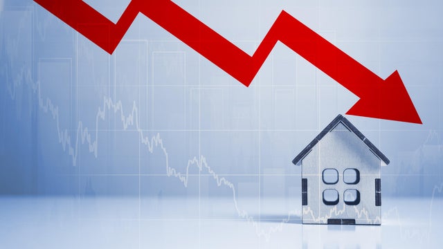 real estate and construction crisis. Real estate market crash due to recession economic downturn crisis. Arrow to down and model house on blue background. copy space 