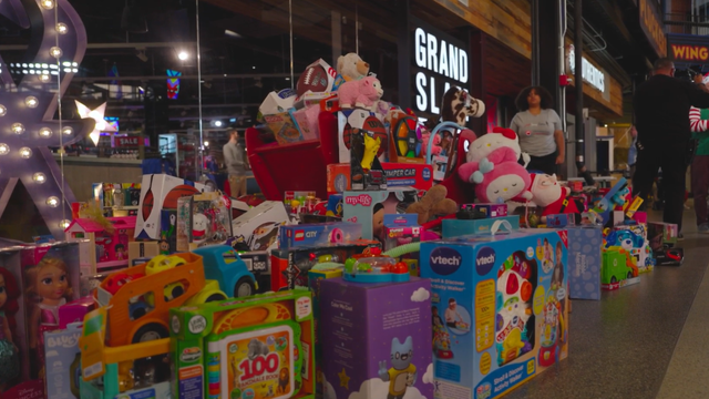Group of Christmas gifts in front of tree. 