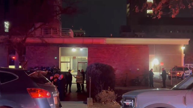 Close Up Shot Focused on Yellow Tape Showing Text Police Line Do Not Cross. Restricted Area of a Crime Scene. Bokeh Background with Flickering Siren Lights. Forensics Team Working on a Case 