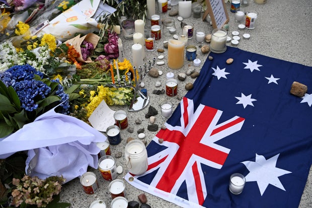 An Australian flag is placed near flowers laid as a tribute to honor the victims of a terror attack that targeted a Hanukkah celebration at Bondi Beach in Sydney, Australia, Dec. 16, 2025.