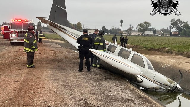 A downed aircraft is surrounded by emergency crews 