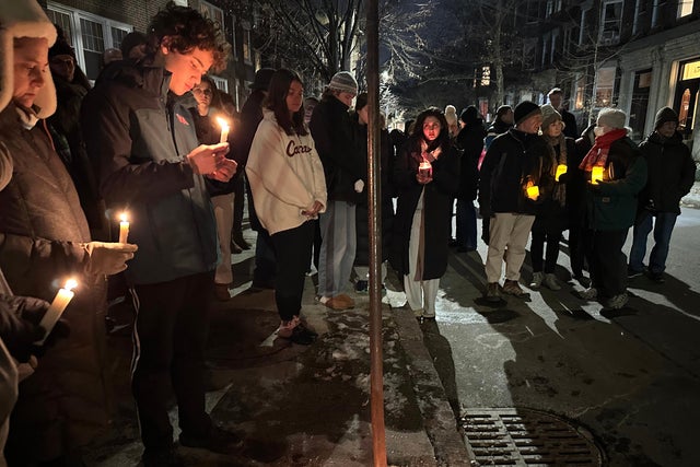 A crowd of people holding candles gather outside the home of Massachusetts Institute of Technology professor Nuno F.G. Loureiro in Brookline, Massachusetts, Dec. 16, 2025.