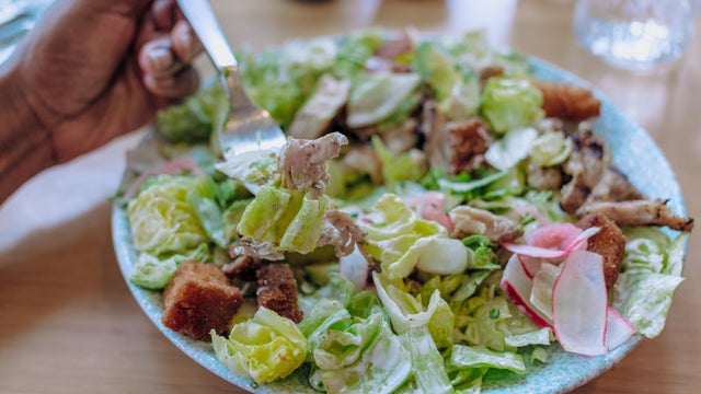 Woman Eats Grilled Chicken Chopped Salad at Restaurant 