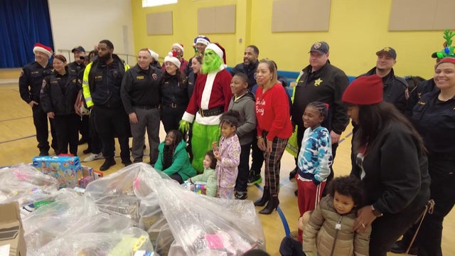 The Essex County sheriff, a group of officers and the Grinch bring toys to students 