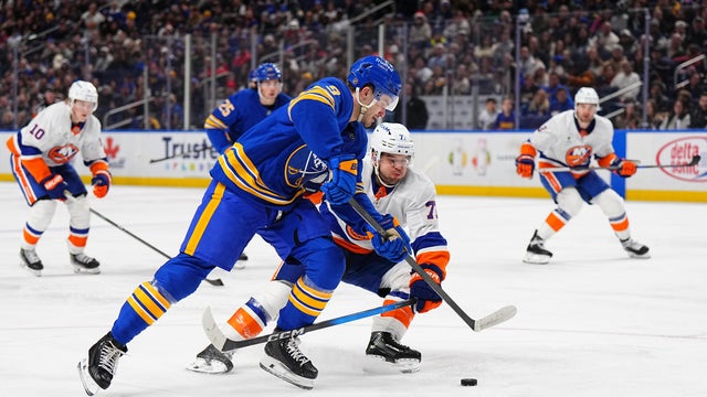 Josh Norris #9 of the Buffalo Sabres battles for the puck against Tony Deangelo #77 of the New York Islanders during the second period of an NHL game on December 20, 2025 at KeyBank Center in Buffalo, New York. 