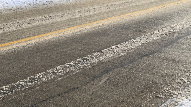 Close-up of a asphalt paved roadway covered with slushy snow 