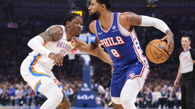 Philadelphia 76ers forward Paul George (8) handles the ball against Oklahoma City Thunder guard Jalen Williams, left, during the first half of an NBA basketball game 