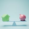Balance between budget and house  with piggy bank 