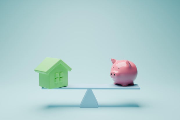Balance between budget and house  with piggy bank 