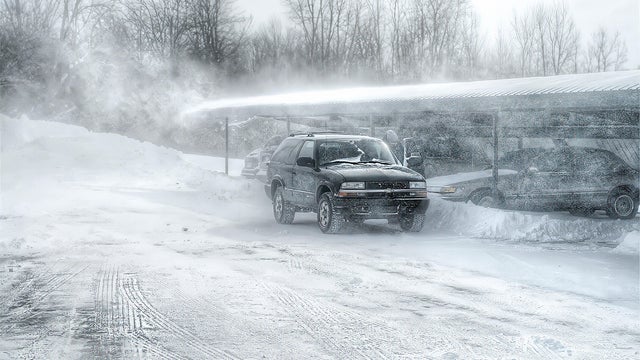 Snow blowing across a parking lot 