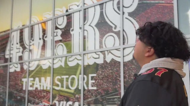A man looks at a San Francisco 49ers sign 