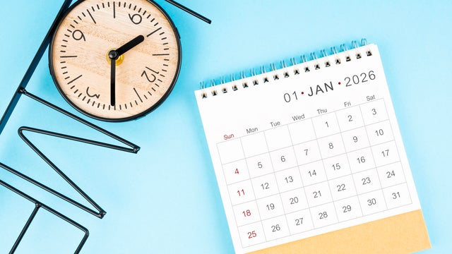 January desk calendar for 2026 year with clock on blue color background, Flat lay. 