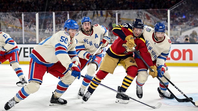 Carter Verhaeghe #23 of the Florida Panthers is defended by Will Cuylle #50, Mika Zibanejad #93 ad Carson Soucy #24 of the New York Rangers during the second period in the 2026 Discover NHL Winter Classic at loanDepot Park on January 02, 2026 in Miami, Florida. 