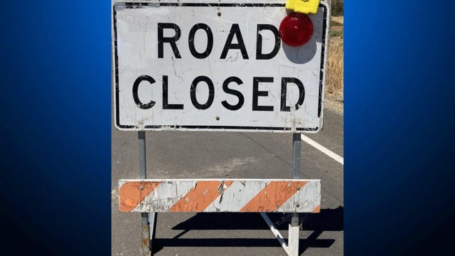 A sign placed on a roadway that reads, "road closed." 