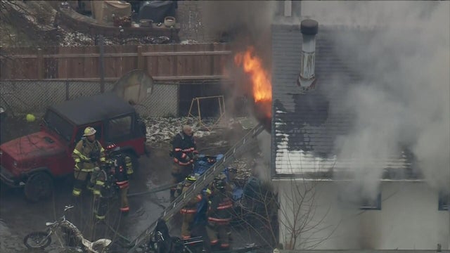 Firefighters respond to the fire, flames are seen coming from the home and heavy smoke is rising 