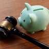 Gavel and Piggy Bank on Wooden Table 